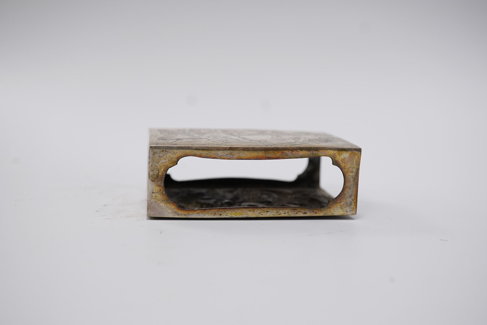 A Chinese Export white metal matchbox holder, with Chinese character mark stamp, embossed and engraved with dragon and prunus, 60mm and a pair of white metal figural menu holders, unmarked.